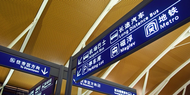 Direction sign in Chinese and English inside Shanghai Pudong Airport