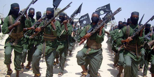 FILE - In this Thursday, Feb. 17, 2011 file photo, al-Shabab fighters march with their weapons during military exercises on the outskirts of Mogadishu, Somalia. A U.S. drone strike in Somalia has targeted a key leader of the al-Shabab militant group who was involved in two attacks in Mogadishu more than a year ago that killed more than 30 people, at least three Americans among them, the Pentagon said Friday, April 1, 2016. Several U.S. officials said he and two others were killed. Hassan Ali Dhoore was targeted in the airstrike Thursday, but the U.S. military was still assessing the results, Pentagon spokesman Peter Cook said in a statement. (AP Photo/Mohamed Sheikh Nor, File)