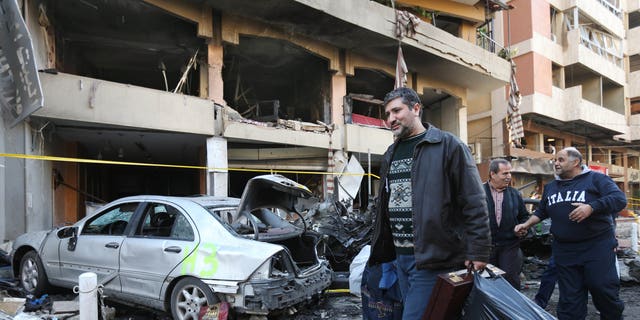 A Lebanese man carries his belongings as he leaves his damaged house at the site of an explosion in a stronghold of the Lebanese Shiite group Hezbollah in Beirut, Lebanon, Friday, Jan. 3, 2014. An explosion tore through a crowded commercial street Thursday in a south Beirut neighborhood that is bastion of support for the Shiite group Hezbollah, killing several people, setting cars ablaze and sending a column of black smoke above the Beirut skyline. (AP Photo/Hussein Malla)