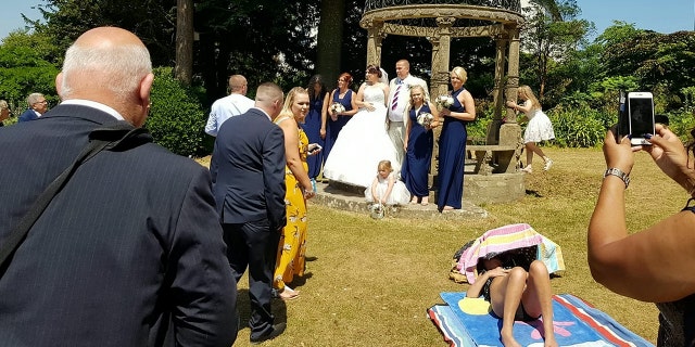 A sunbathing woman allegedly refused to move out a couple's wedding photos.