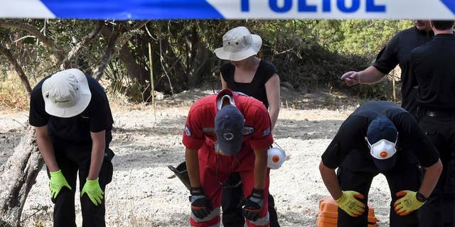 FILE - In this Monday, Sept. 26, 2016 file photo, British officers and members of the Greek rescue team search an area of land on the southeastern Greek island of Kos. A British toddler who went missing on a Greek island 25 years ago is believed to have been killed in a construction-site accident that was covered up for almost a quarter of a century, police said Monday, Oct. 17, 2016. (Nikos Panagiotopoulos/InTime News via AP, file)