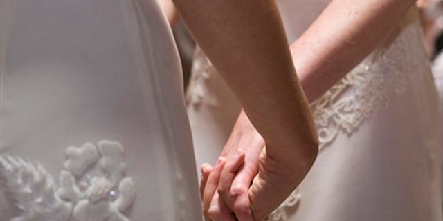 FILE - In this June 17, 2008 file photo, Amber Weiss and Sharon Papo, both of Berkeley, Calif., hold hands during their wedding ceremony at City Hall in San Francisco. What public schools will be required to teach about same-sex marriage has emerged as the central issue in the campaigns against same-sex marriage in both California and Maine.(AP Photo/Darryl Bush, FILE)