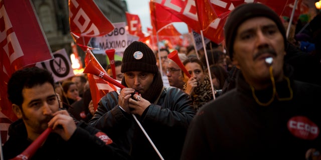 People blow whistles and horns during a demonstration against job cuts at bailed-out bank Bankia in Madrid Wednesday Jan. 23, 2013. Spain's recession deepened in the fourth quarter of 2012, when the economy shrank by 0.6 percent compared with the previous three-month period, according to preliminary estimates from the Bank of Spain on Wednesday.(AP Photo/Daniel Ochoa de Olza)
