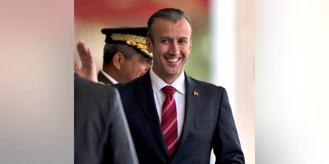 FILE - In this Feb. 1, 2017 photo, Venezuela's then-Vice President, Tareck El Aissami, right, is saluted by Boilivarian Army officer upon his arrival for a military parade at Fort Tiuna in Caracas, Venezuela.
