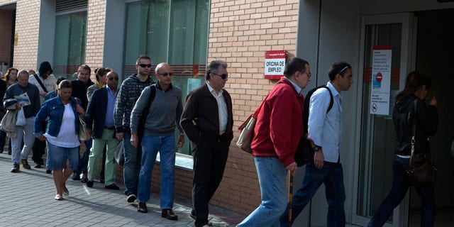 People enter an unemployment registry office in Madrid, Spain Monday May 6, 2013. Spain’s Labor Ministry said the number of people registered as unemployed fell by 46,050 in April with more people finding jobs in the run-up to the summer tourist season. Spain has been in recession for the best part of the past four years as the economy battles to recover from the collapse of its once-booming real estate sector. The total number registered as jobless stands at 4.99 million. (AP Photo/Paul White)