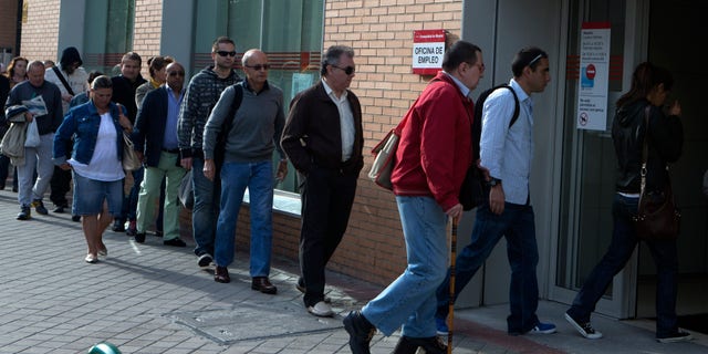 People enter an unemployment registry office in Madrid, Spain Monday May 6, 2013. Spain’s Labor Ministry said the number of people registered as unemployed fell by 46,050 in April with more people finding jobs in the run-up to the summer tourist season. Spain has been in recession for the best part of the past four years as the economy battles to recover from the collapse of its once-booming real estate sector. The total number registered as jobless stands at 4.99 million. (AP Photo/Paul White)