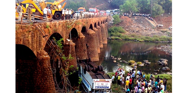 March 19, 2013: Rescuers and others gather at the site of a bus accident in Ratnagiri district, in the western Indian state of Maharashtra.