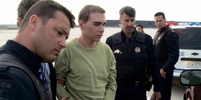 June 18, 2012: In this file photo provided by Montreal Police, Luka Rocco Magnotta is taken by police from a Canadian military plane to a waiting van in Mirabel, Quebec.