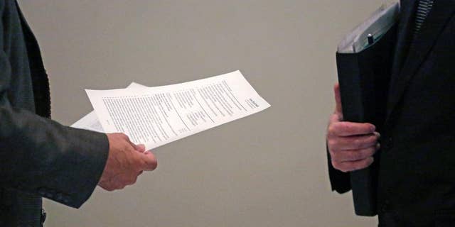 In this April 22, 2015 photo, a corporate recruiter, left, and a job applicant, right, speak during a National Career Fairs job fair in Chicago. The U.S. Labor Department reports on the number of people who applied for unemployment benefits during the week ending April 25 on Thursday, April 30, 2015. (AP Photo/M. Spencer Green)