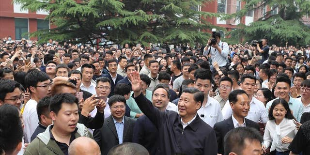 In this Wednesday, May 3, 2017 photo released by Xinhua News Agency, Chinese President Xi Jinping, center, waves to teachers and students as he visits the China University of Political Science and Law in Beijing. Xi has discussed North Korea during a phone call with Philippine President Rodrigo Duterte, who referred to Beijing's important role in promoting peace on the Korean Peninsula. (Ding Lin/Xinhua via AP)
