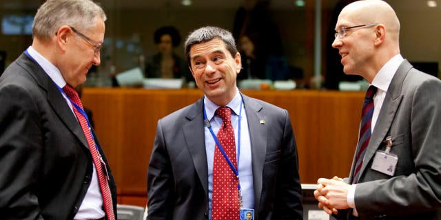 CEO of the European Financial Stability Facility, Klaus Regling, left, and member of the board of the ECB Joerg Asmussen, right, speak with Portugal's Finance Minister Vitor Gaspar during a meeting of EU finance ministers at the EU Council building in Brussels on Tuesday, Jan. 22, 2013. Eleven eurozone countries seeking to unilaterally implement a financial transaction tax are expected Tuesday to receive the blessing of other European Union countries, bringing the once-controversial project one step closer to reality. (AP Photo/Virginia Mayo)