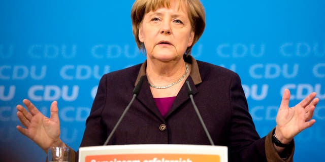 German Chancellor Angela Merkel speaks during a press conference in Berlin , Germany, Sunday Dec. 15, 2013. Germany will get its first female defense minister in Chancellor Angela Merkel's new government, while the country's influential finance minister will stay in his job. Merkel confirmed Sunday that Ursula von der Leyen, currently labor minister, will become defense chief. The 55-year-old mother of seven inherits the job of modernizing the German military and overseeing its deployment in Afghanistan. Finance Minister Wolfgang Schaeuble, Merkel's co-pilot in fighting Europe's debt crisis, will stay on. Sign reads : Together Successful. (AP Photo/Christian Thiel)