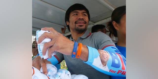 FILE - In this Friday, May 6, 2016, file photo, Congressman Manny Pacquiao, who is running for senator in the national elections, smiles from a campaign vehicle during a campaign rally in Navotas,north of Manila, Philippines. The boxing great appears to have won a seat in the Philippine Senate, according to unofficial results. Pacquiao has garnered more than 15 million votes, with about 93 percent of precincts reporting Tuesday, May 10, 2016. (AP Photo/Bullit Marquez, File)