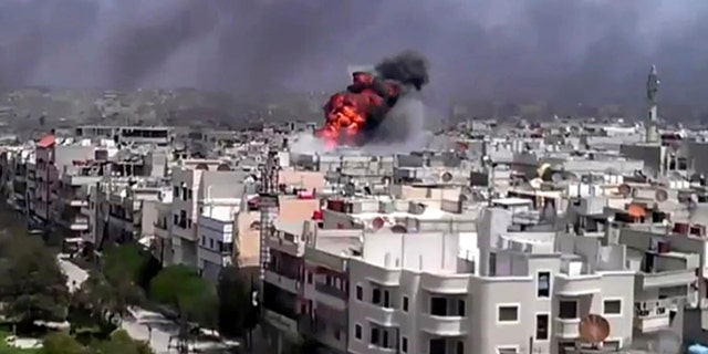 April 20: This image made from amateur video and released by Shaam News Network purports to show an explosion amid heavy shelling in the Khaldiyeh area of Homs, Syria.