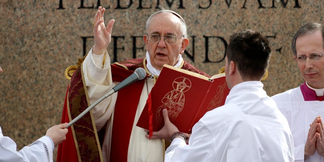 Pope Francis celebrates Palm Sunday Mass, in St. Peter's Square at the Vatican, Sunday, March 24, 2013. The new pontiff arrived in an uncovered vehicle to start solemn Holy Week ceremonies, which lead up to Easter, Christianity's most important day. Francis wore bright red robes over a white cassock and presided over the Mass from an altar sheltered by a canopy on the steps of St. Peter's Basilica. (AP Photo/Andrew Medichini)