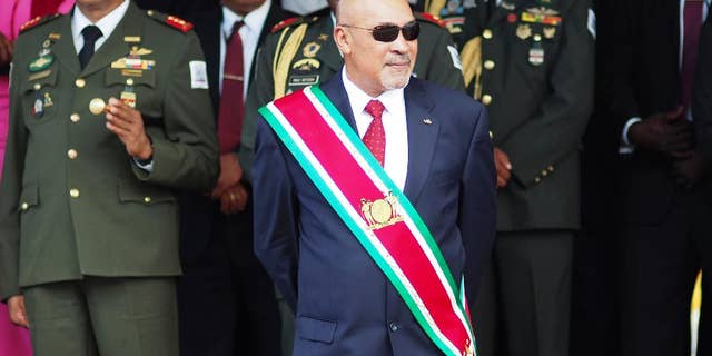 FILE - In this Aug. 12, 2015 file photo, Suriname President Desire Delano Bouterse observes a military parade, after being sworn in for his second term, in Paramaribo, Suriname. A military court in Suriname on Monday, Jan. 30, 2017, ordered the president to resume his long-stalled murder trial in the killing of political opponents under his dictatorship in 1982. (AP Photo/Ertugrul Kilic, File)