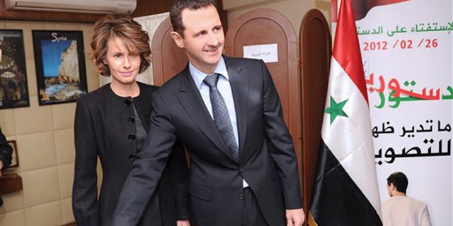 Feb. 26, 2012: In this photo released by the Syrian official news agency SANA, Syrian President Bashar Assad casts his ballot next to his wife Asma at a polling station in Damascus, Syria.