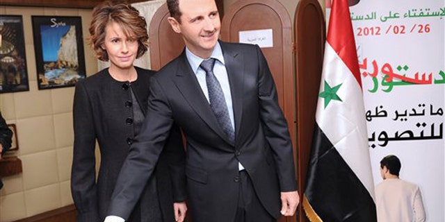 Feb. 26, 2012: In this photo released by the Syrian official news agency SANA, Syrian President Bashar Assad casts his ballot next to his wife Asma at a polling station in Damascus, Syria.