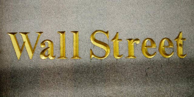 FILE - This Oct. 8, 2014 file photo shows a Wall Street address in the side of a building in New York. U.S. stocks are opening lower Tuesday, March 10, 2015, reversing a gain from the day before, following declines in European markets. (AP Photo/Mark Lennihan, File)