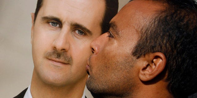 Jan. 4, 2012: A pro-Syrian regime protester kisses a portrait of Syrian President Bashar Assad during a demonstration in support of their President, in Damascus, Syria.