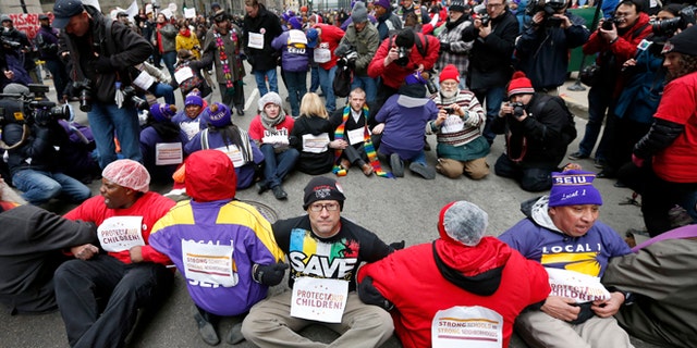 March 27, 2013: Protesters sit on LaSalle Street during an act of civil disobedience over a plan to close 54 Chicago Public Schools in  Chicago's downtown.