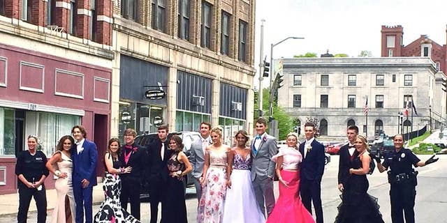 Two officers with Maine's Bangor Police Department posed for a prom photo with high school students after they were reported to police for blocking the street.