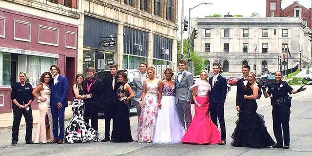 Two officers with Maine's Bangor Police Department posed for a prom photo with high school students after they were reported to police for blocking the street.
