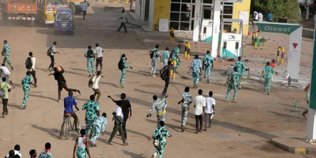 Sudanese protestors throw stones at a petrol station in Khartoum's twin city of Omdurman during a demonstration after the government announced steep price rises for petroleum products on September 25, 2013