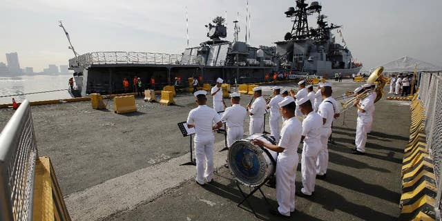 A Philippines Navy Band plays as the Russian Navy vessel Admiral Tributs, a large anti-submarine ship, docks at Manila's pier on Tuesday.