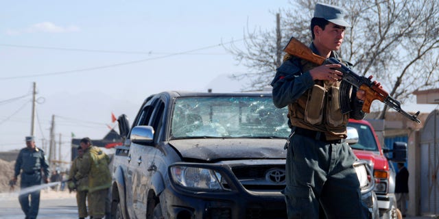 An Afghan policeman secures the area where a suicide bomber attacked the deputy governor of Balkh province in Mazar-e-Sharif, northern Afghanistan, Sunday, Nov. 17, 2013.  While the official escaped unhurt, at least one civilian was killed, said Balkh police spokesman Sher Jan Durrani.  (AP Photo/Mustafa Najafizada)