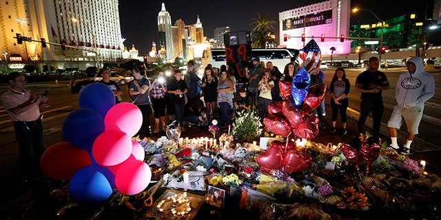 People gather at a makeshift memorial in the middle of Las Vegas Boulevard following the mass shooting in Las Vegas, Nevada, U.S., October 4, 2017.