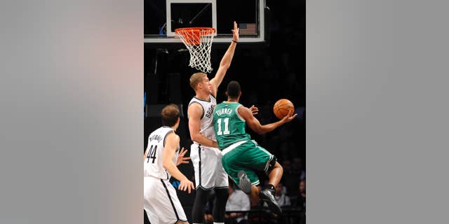 Brooklyn Nets forward Mason Plumlee (1) blocks a shot by Boston Celtics guard Evan Turner (11) as Nets forward Bojan Bogdanovic (44) defends from behind during the first half of a preseason NBA basketball game on Sunday, Oct. 19, 2014 at Barclays Center in New York. (AP Photo/Kathy Kmonicek)