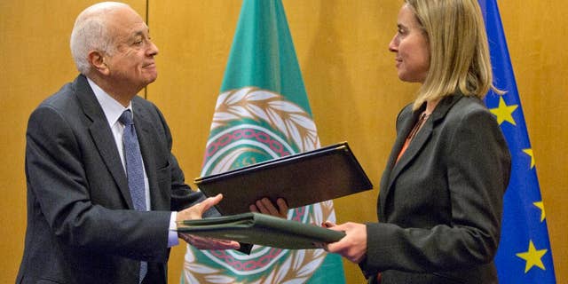 Secretary General of the Arab League Nabil Al-Araby, left, exchanges booklets with European Union High Representative Federica Mogherini after signing a cooperation agreement after a meeting of EU foreign ministers in Brussels on Monday, Jan. 19, 2015. The European Union is calling for an anti-terror alliance with Arab countries to boost cooperation and information sharing in the wake of deadly attacks and arrests across Europe linked to foreign fighters. (AP Photo/Virginia Mayo)