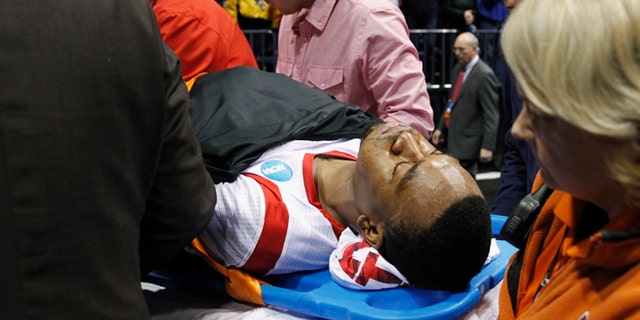 Louisville guard Kevin Ware is taken off of the court on a stretcher after his injury during the first half of the Midwest Regional final against Duke in the NCAA college basketball tournament Sunday March 31, 2013, in Indianapolis. (AP Photo/Darron Cummings)