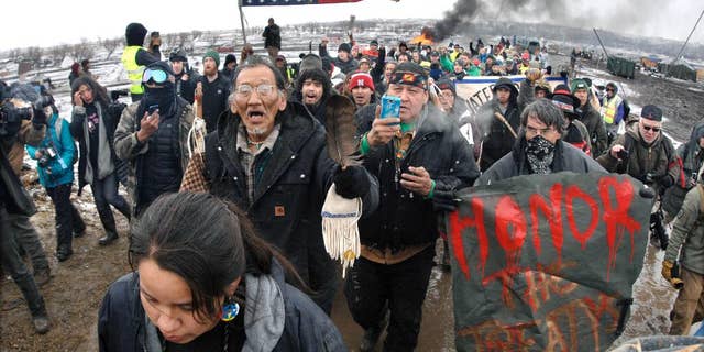 FILE - In this Feb. 22, 2017, file photo, a large crowd representing a majority of the remaining Dakota Access Pipeline protesters march out of the Oceti Sakowin camp before the 2 p.m. local time deadline set for evacuation of the camp mandated by the U.S. Army Corps of Engineers near Cannon Ball, N.D. American Indians from across the country are bringing their frustrations with the Trump administration and its approval of the Dakota Access oil pipeline to the nation's capital Tuesday, March 7, 2017, kicking off four days of activities that will culminate in a march on the White House. (Mike McCleary/The Bismarck Tribune via AP, File)