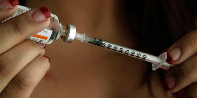 Judith Garcia, 19, fills a syringe as she prepares to give herself an injection of insulin at her home in the Los Angeles suburb of Commerce, Calif., Sunday, April 29, 2012. A major study, released Sunday, tested several ways to manage blood sugar in teens newly diagnosed with diabetes and found that nearly half of them failed within a few years and 1 in 5 suffered serious complications. Garcia still struggles to manage her diabetes with metformin and insulin years after taking part in the study at Children's Hospital Los Angeles. (AP Photo/Reed Saxon)