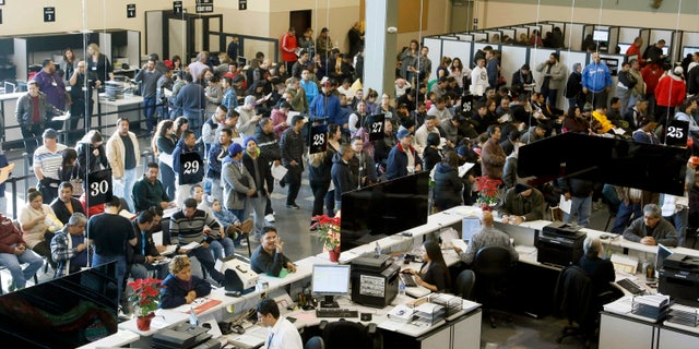 Immigrants line up at a California Department of Motor Vehicles in Stanton, Calif., Friday, Jan. 2, 2015.