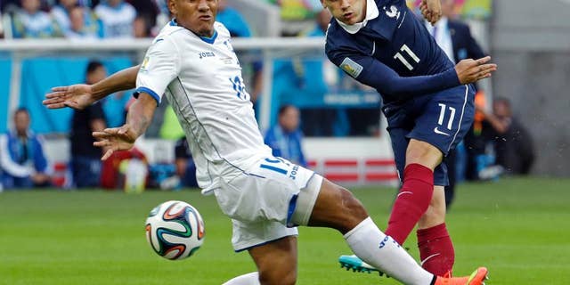 France's Antoine Griezmann drills the ball past Honduras' Luis Garrido during the group E World Cup soccer match between France and Honduras at the Estadio Beira-Rio in Porto Alegre, Brazil, Sunday, June 15, 2014. (AP Photo/Fernando Vergara)