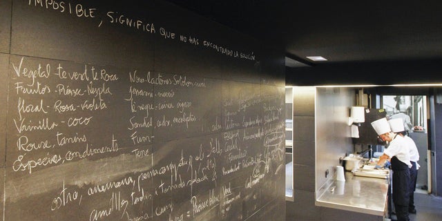 A blackboard of the restaurant "El Celler de Can Roca" reads "Impossible, means that you didn't find the solution" past employees working in the kitchen in Girona on June 2, 2015. Spain's "El Celler de Can Roca" was crowned the world's best restaurant on June 1, 2015 winning praise for the "collective genius" of the three brothers who run it. It was the second time the Girona eatery has topped the World's 50 Best Restaurant awards in London, after taking the number one spot in 2013. AFP PHOTO/ QUIQUE GARCIA (Photo credit should read QUIQUE GARCIA/AFP/Getty Images)