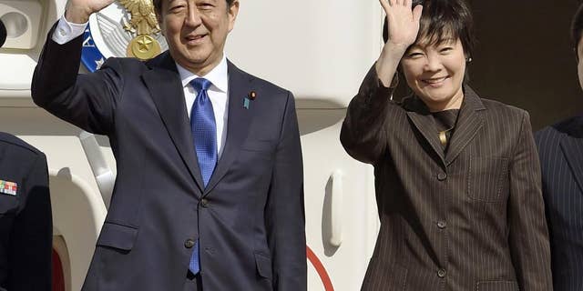 安倍晋三日本首相と奥さんの秋江夫人が2016年11月、東京羽田空港からニューヨークに出発する前に手を振っている。