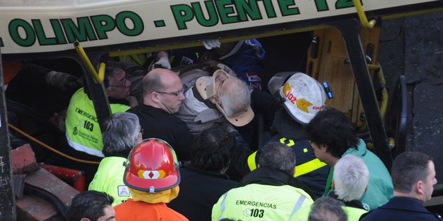 A wounded passenger is carried out a train after it crashed in Buenos Aires, Argentina, Tuesday, Sept. 13, 2011. At least seven people were killed and at least 162 injured in a rush-hour crash Tuesday involving two passenger trains and a bus whose driver drove around barriers in an attempt to beat them across the tracks, Argentine authorities said.
