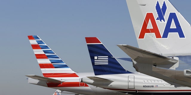 U.S. Airways and American Airlines planes are shown at gates at DFW International Airport in Grapevine, Texas.