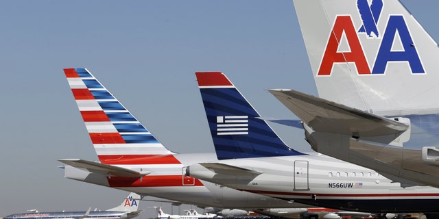 U.S. Airways and American Airlines planes are shown at gates at DFW International Airport in Grapevine, Texas.