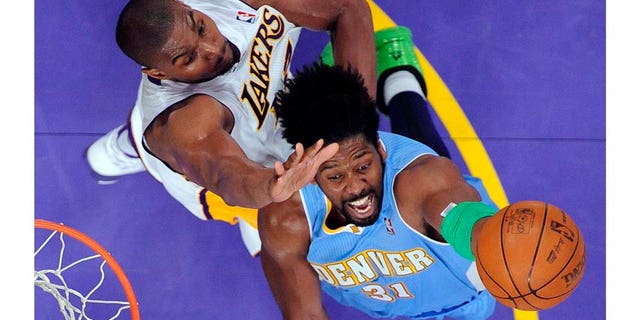 Denver Nuggets center Nene, right, of Brazil, puts up a shot as Los Angeles Lakers center Andrew Bynum defends during the second half of an NBA basketball game, Sunday, April 3, 2011, in Los Angeles. The Nuggets won 95-90. (AP Photo/Mark J. Terrill)