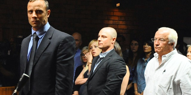 Feb. 19, 2013: Olympian Oscar Pistorius stands following his bail hearing, as his brother Carl, center, and father Henke look on, in Pretoria, South Africa.
