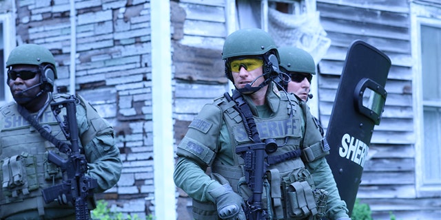 Investigator Kris Coughlin, Investigator Donald Edwards, and Officer Julian Evans during a training exercise.