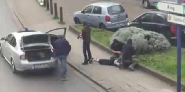 In this image made from video, police arrest a man in the Anderlecht area of Brussels, Friday, April 8, 2016. A fugitive suspect in the Nov. 13 Paris attacks was arrested in Belgium on Friday, French police officials said, after a raid Belgian authorities said was linked to the deadly March 22 Brussels bombings. The suspect, Mohamed Abrini, is believed to be the mysterious "man in the hat" who escaped the double bombing at the Zaventem airport, according to one of the French officials. (Sebastian Kamran via AP)