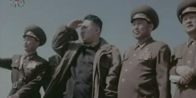 In this undated image made from KRT video, North Korea's new young leader Kim Jong Un, third from right, watches jet fighters with North Korean officials at an undisclosed place in North Korea.