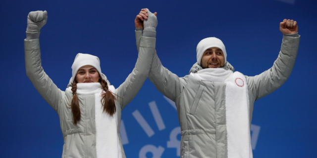 Anastasia Bryzgalova and Alexander Krushelnitsky, "Olympic Athletes from Russia," on the podium at the 2018 Winter Olympic Games.