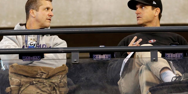 San Francisco 49ers head coach Jim Harbaugh, right, talks with Baltimore Ravens head coach John Harbaugh at the NFL football scouting combine in Indianapolis, Saturday, Feb. 22, 2014. (AP Photo/Nam Y. Huh)